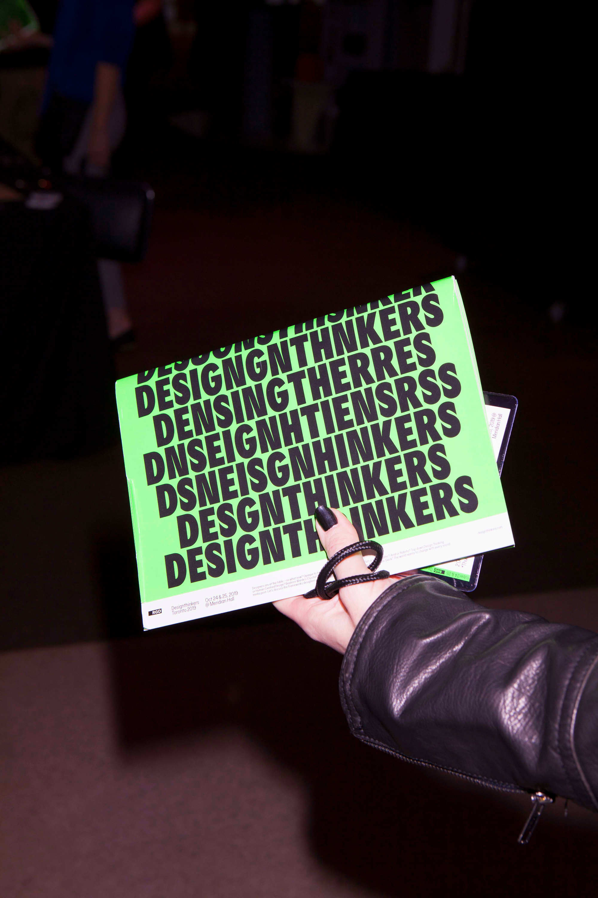 Hand holding a Design Thinkers booklet.